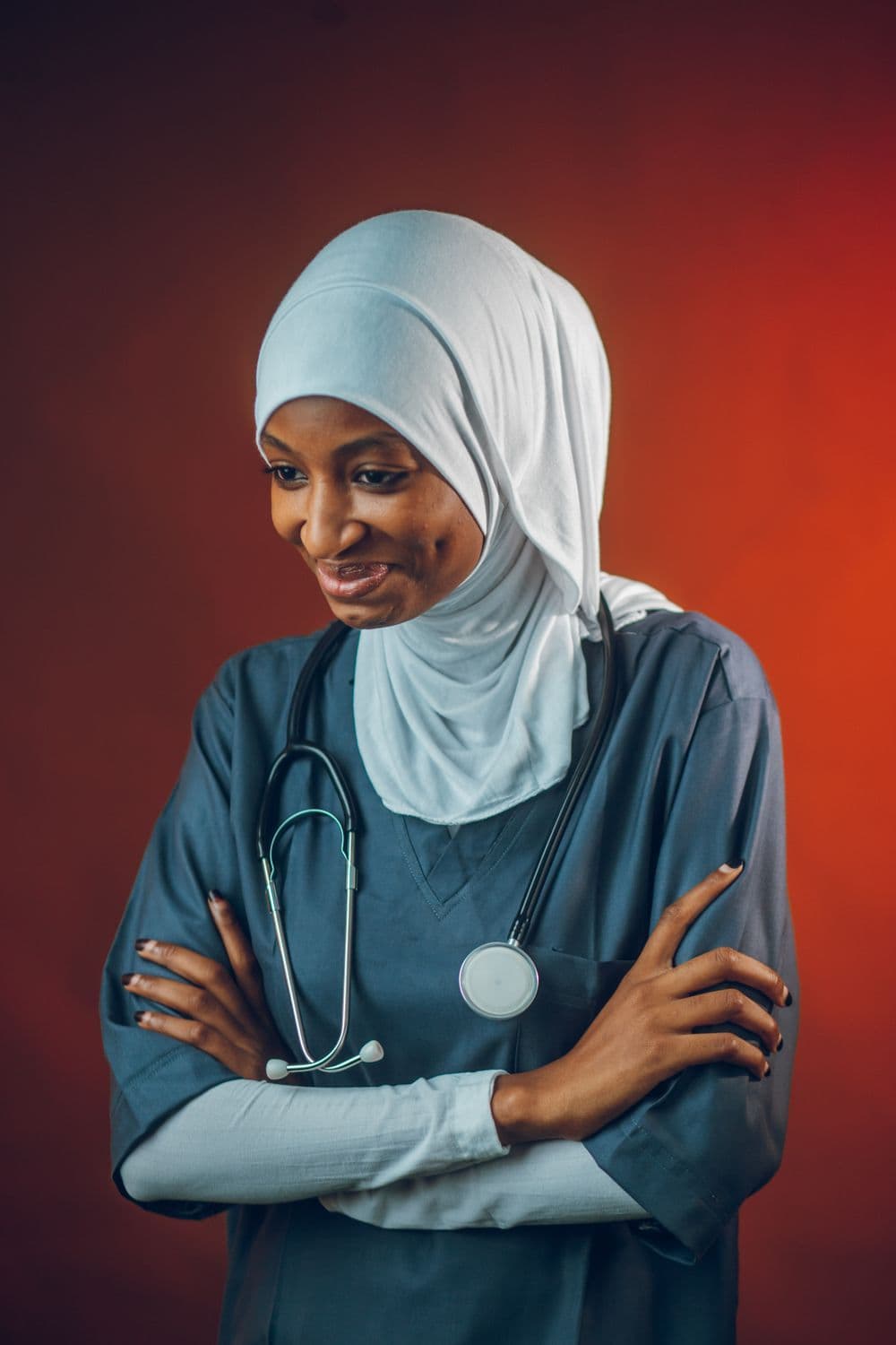 A smiling Ugandan healthcare worker wearing a stethoscope and hijab